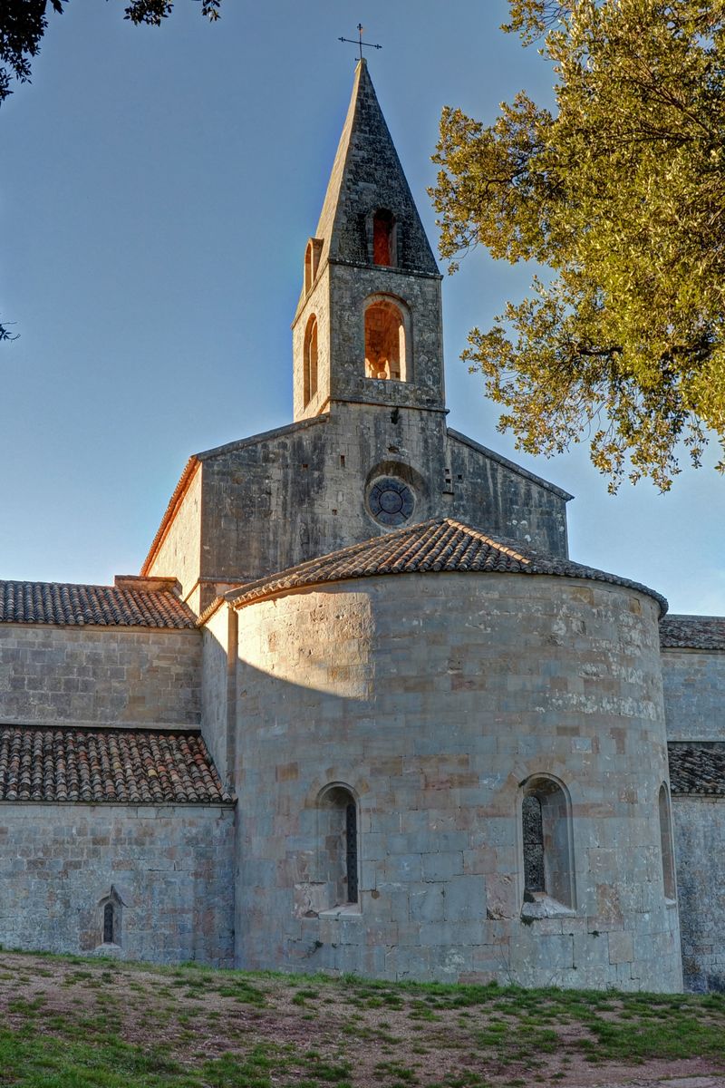 Il chiostro e la chiesa in pietra calcarea chiara dell'Abbazia di Thoronet, immersi nella campagna provenzale del Var, Francia
